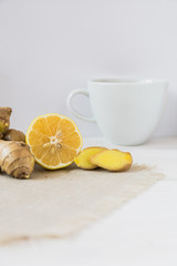 Cup of tea with lemon and ginger on a white background. The concept of tea from colds and to improve immunity. Detox drink components