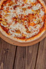 Hawaiian pizza on dark rustic wooden background. Top view, copy space