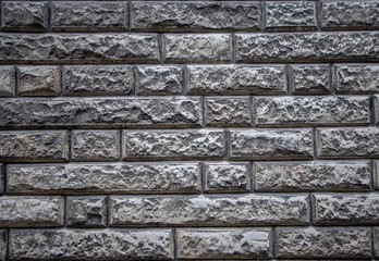 Textural background of an old stone wall made of limestone. Neatly cut gray bricks and good masonry.