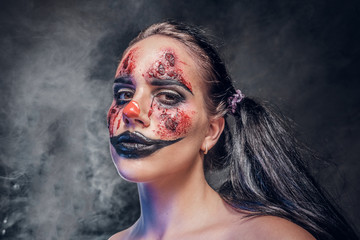 Evil psycho clown makeup looks especially creepy in a smoke over dark background.