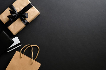 Black friday sale concept. Frame made of gift box, credit card, shopping bag over black background