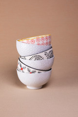 Stacked white bowls on a neutral background with text space. 