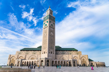 View of Hassan II mosque against blue sky - The Hassan II Mosque or Grande Mosquée Hassan II is a mosque in Casablanca, Morocco. - obrazy, fototapety, plakaty