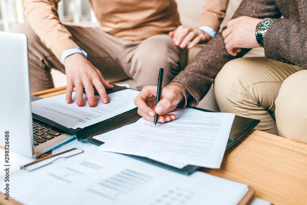 Leinwandbilder one of business partners with pen pointing at contract while reading it