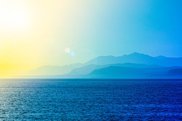 Sea and mountains blue sunset landscape. Haze silhouette.