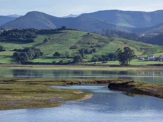 Cantabria landscape with field, montains, river and a small village. Spain