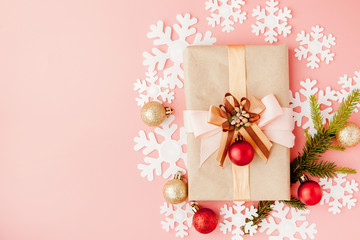 Close up shot of small gift wrapped with ribbon on pink background. Christmas background. Minimal concept. Flat lay. Top view