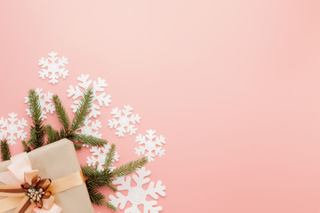 Close up shot of small gift wrapped with ribbon on pink background. Christmas background. Minimal concept. Flat lay. Top view