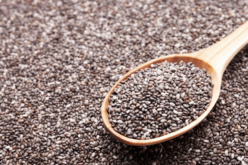 Chia seeds in wooden spoon closeup view. Super food concept. Space for text