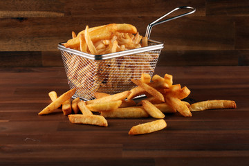 Tasty french fries potato on wooden table background