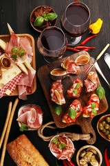 Italian antipasti wine snacks set. Cheese variety, Mediterranean olives, Prosciutto di Parma, tomatoes, artichokes