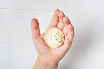 Fototapeta premium Bitcoin coin in a child's hand. Close up.