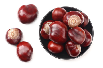 chestnuts in a black plate isolated on white background. top view