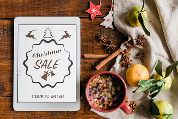 Christmas background with touchpad, drink, clementines, spices and decorations