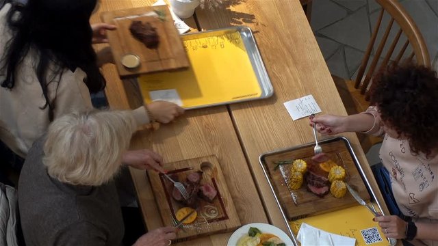 People eat at a table in a restaurant. View from above.