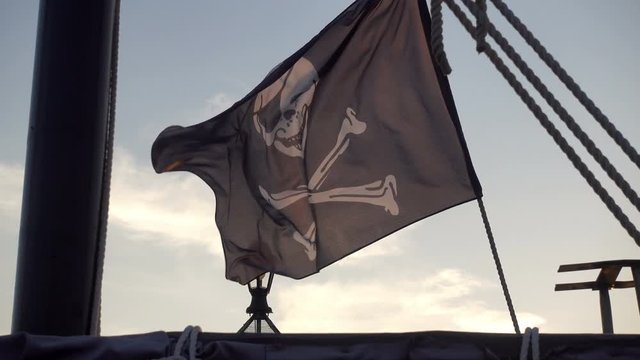 Black pirate flag waving on a ship in 4K.
