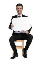 Cheerful businessman smiling and holding a speech bubble