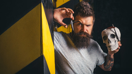 Hairdresser makes hairstyle a man with a beard. Bearded man getting haircut by hairdresser and sitting in chair at barbershop. Bearded client visiting barber shop. Bearded man.