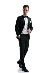 elegant fashion man wearing tuxedo and looking to side