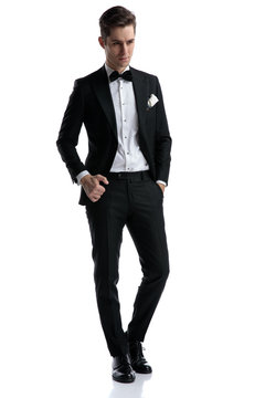 young elegant groom wearing tuxedo and looking to side