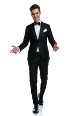 smiling young elegant groom walking and greeting