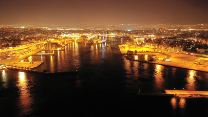 Aerial drone night shot of beautiful illuminated port of Piraeus and huge cruise liner departing to Aegean popular destinations, Attica, Greece