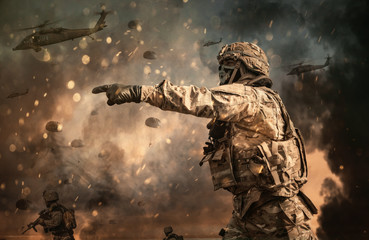 Military helicopter and forces between fire and dust in the battlefield