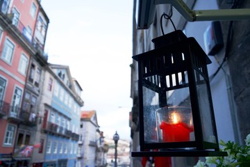 Farol encendido adorno una calle de Oporto