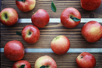 Fresh apples on a wooden board. Harvest of red apples. Fruits and cinnamon on the table.