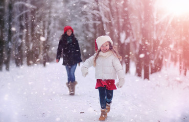 A winter fairy tale in the forest. A girl on a sled with gifts on the eve of the new year in the park. Two sisters walk in a New Year's park and ride a sled with gifts.