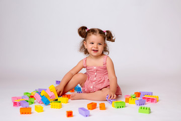 baby girl playing with multicolored constructor, isolate, space for text