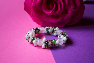 The hand bracelet with decor on pink background.