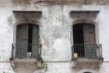 Fototapeta na wymiar Old Residential Building Facade with Rusted Symmetrical Balcony Doors in Casco Viejo Old Town, Panama City