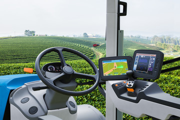 Autonomous tractor working in green tea field, Future technology with smart agriculture farming concept