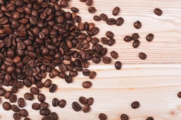 Dark brown whole coffee beans on wood background with copyspace