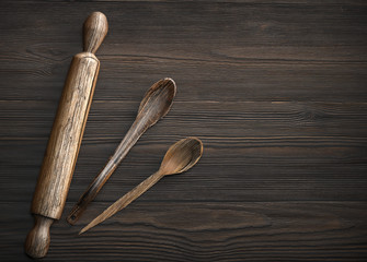 Old wooden spoon and rolling pin on rustic wooden table