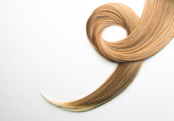 Piece of blonde brown hair on white isolated background