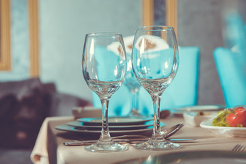 Part of interior . wine glasses on the table in front of the empty wineglass. Empty glasses set in restaurant.