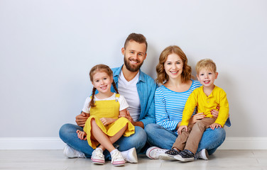 happy family mother father and children daughter and son  near an   grey blank wall.