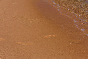 Human footprints on the sandy beach. Summer vacation concept