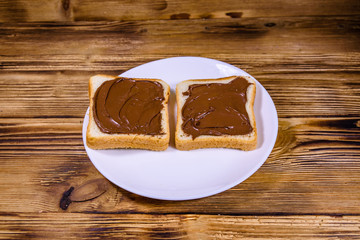 Two sandwiches with chocolate spread on a white plate