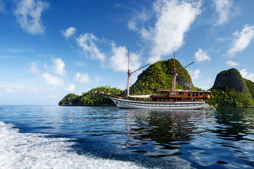 Sail boat between islands of remote archipelago Pulau Wayag, Raja Ampat, Indonesia