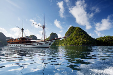 Sail boat between islands of remote archipelago Pulau Wayag, Raja Ampat, Indonesia