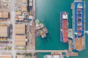 Aerial view of a jack up oil drilling rig and dry dock ship in the shipyard for maintenance