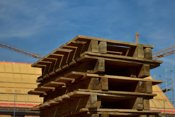 Wooden pallets are stacked on a construction site