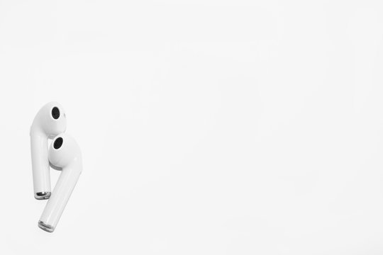 A pair of modern wireless headphones on a white background, space for lettering.