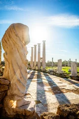 Papier Peint photo Chypre Statue en marbre sous les rayons du soleil et colonnes antiques à Salamine, site archéologique grec et romain, Famagouste, Chypre du Nord