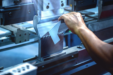 Workers bending sheet metal by CNC machines in industrial plants - obrazy, fototapety, plakaty