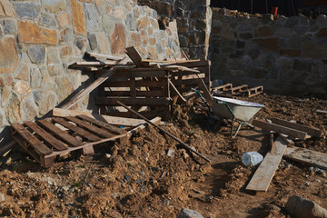 Construction area. Building a new house. A lot of construction garbage. Wheelbarrow and boards on...