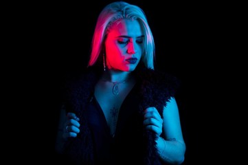 Gothic fashion style girl showing jacket in black background and red and blue colors